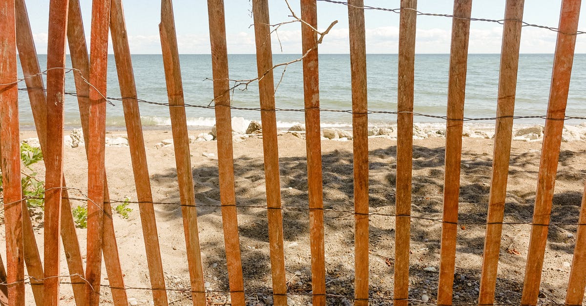 Transiting through Brussels [closed] - Old wooden fence on sandy beach