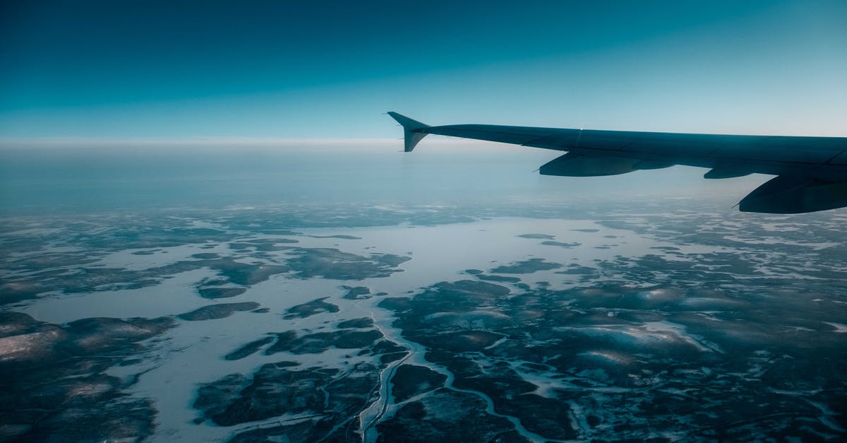 Transport frozen mother's milk by plane - Airplane wing over snowy terrain