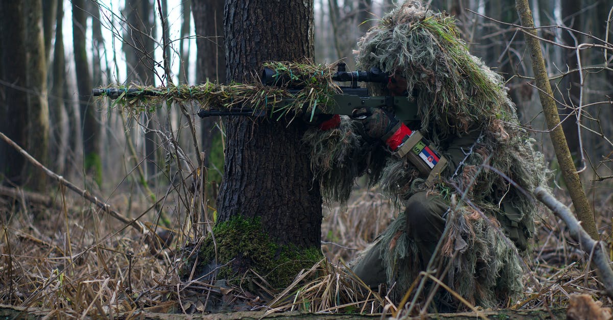 Transporting an airsoft gun from the US to Israel - A Soldier Sniper Aiming Though The Rifle Scope In Forest