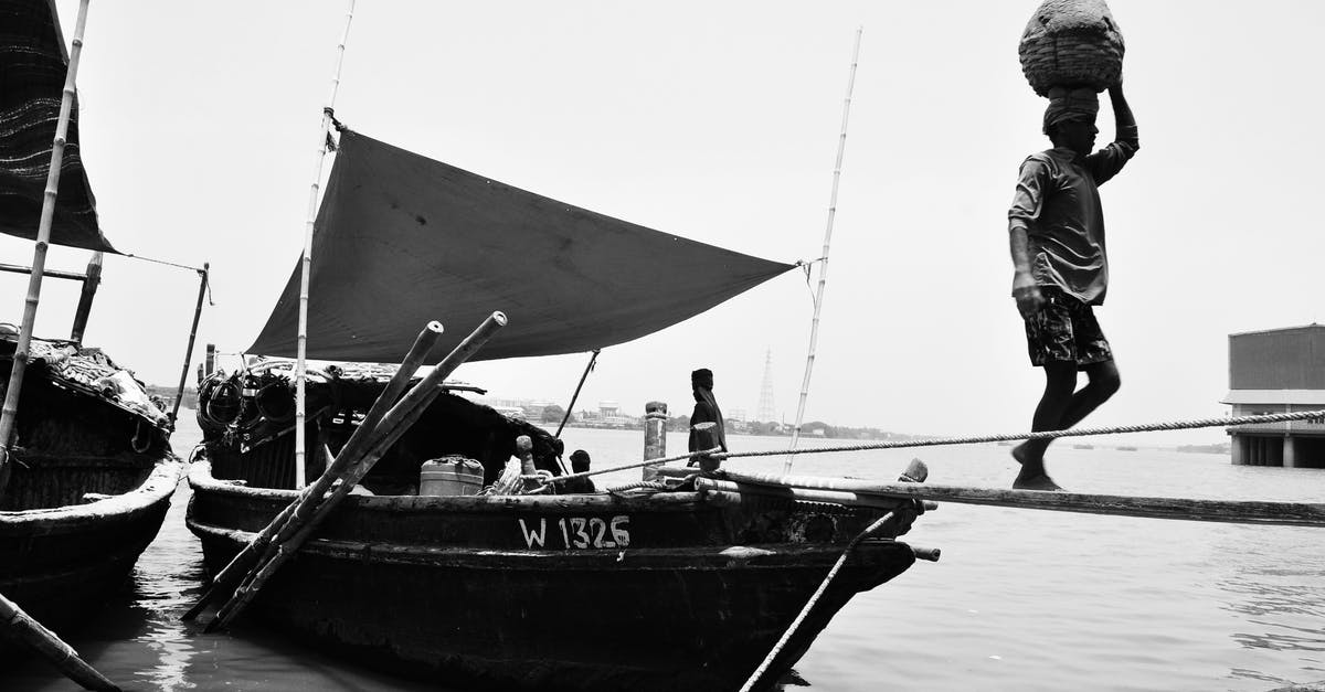 Transporting someone else's goods across US border - Man in Black Jacket and Pants Standing on Boat in Grayscale Photography