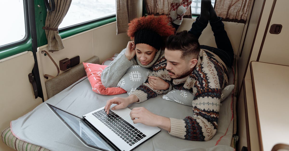 Trans-Siberian trip in August - Couple Using a Laptop while Lying Down on Bed