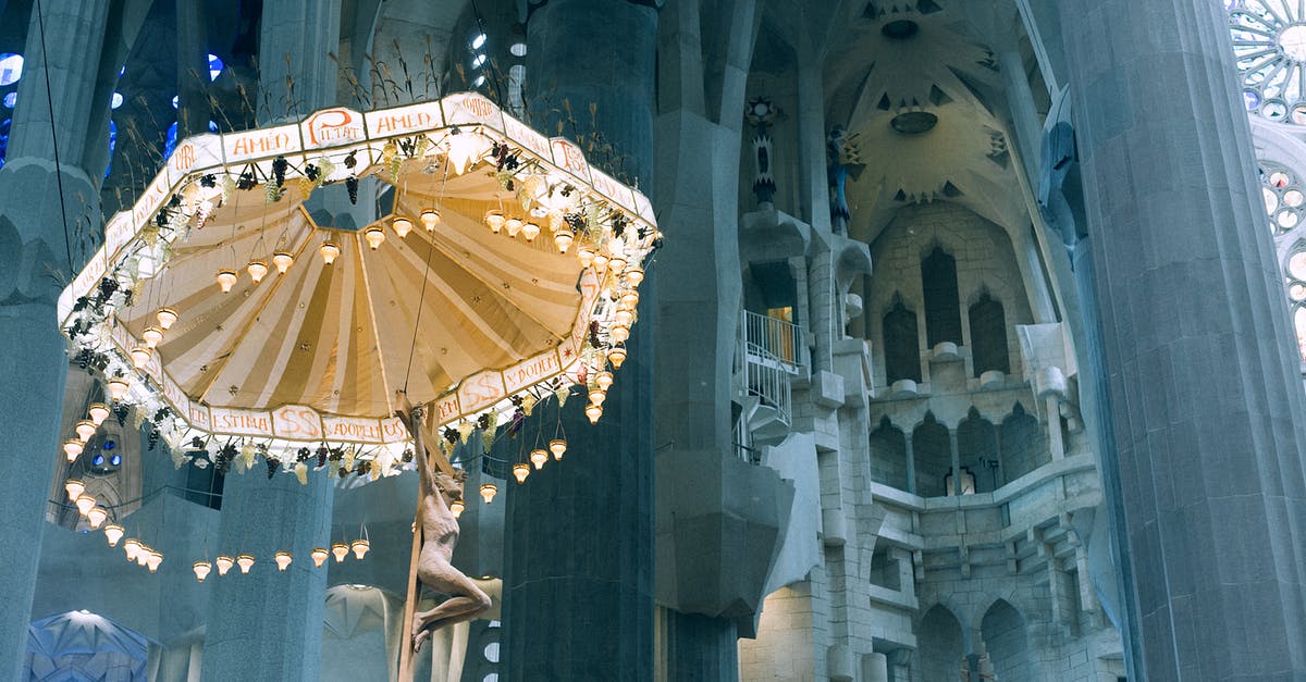 Travel from the UK to Spain with an Italian ID - From below pillars and decorative ceiling with ornamental chandelier in Basilica de la Sagrada Familia in Barcelona