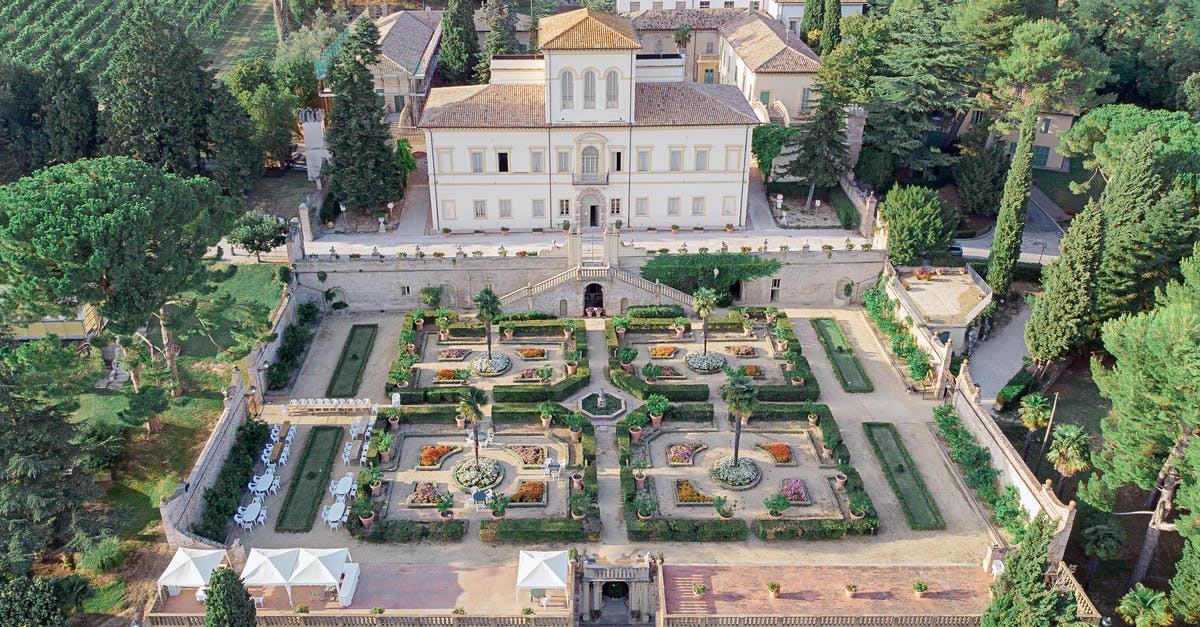 Travel to Italy from the UK - Picturesque aerial view of historic Villa Caprile built in Baroque style with well groomed symmetric garden surrounded by lush green trees in Pesaro