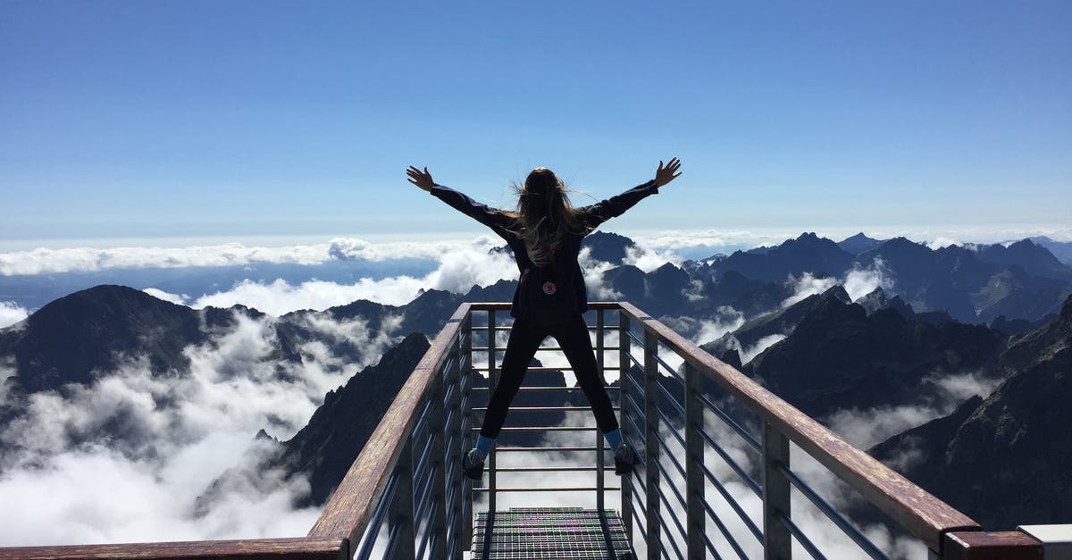 Travel to Lithuania with expired residence and confirmation receipt of renewal process in Slovakia - Person Standing on Hand Rails With Arms Wide Open Facing the Mountains and Clouds