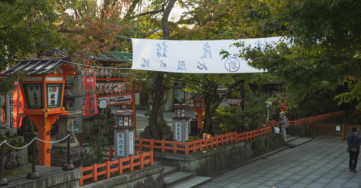 Travel to Okinawa from mainland Japan - From above of building surrounded by lush green tress located on territory of historic Shinto Yasaka Shrine in Kyoto