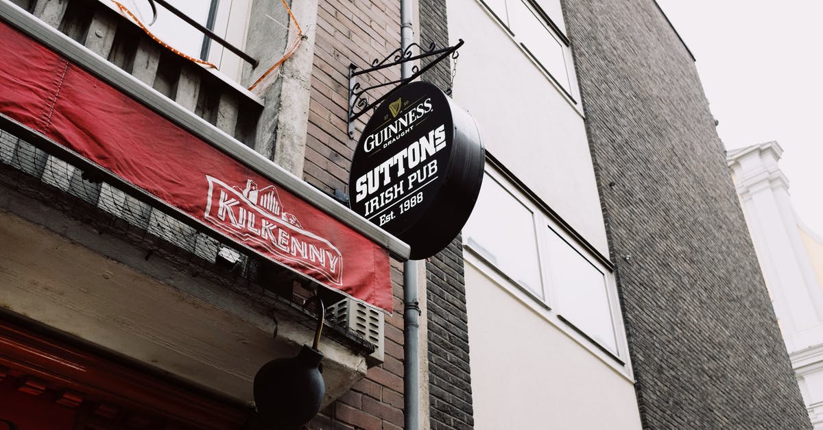 Travel to UK on a business visa from old company - Signboard of beer pub near modern brick building in tourist city