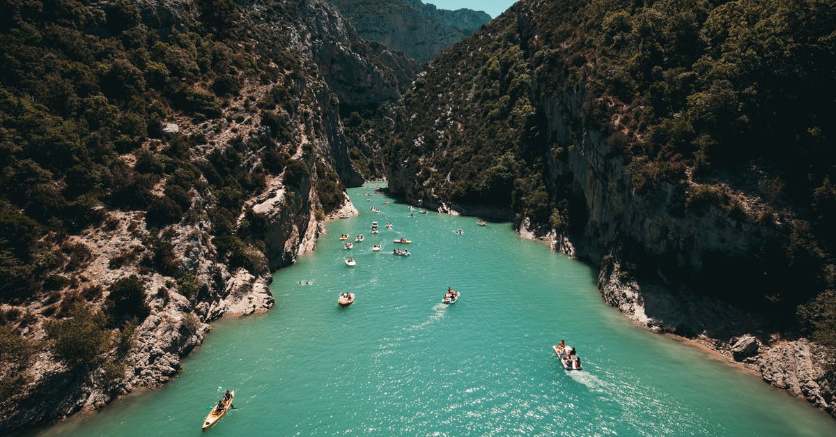 Traveling aboard an ocean liner like in The Royal Tenenbaums? - Photo of People Riding Kayaks Near Mountains