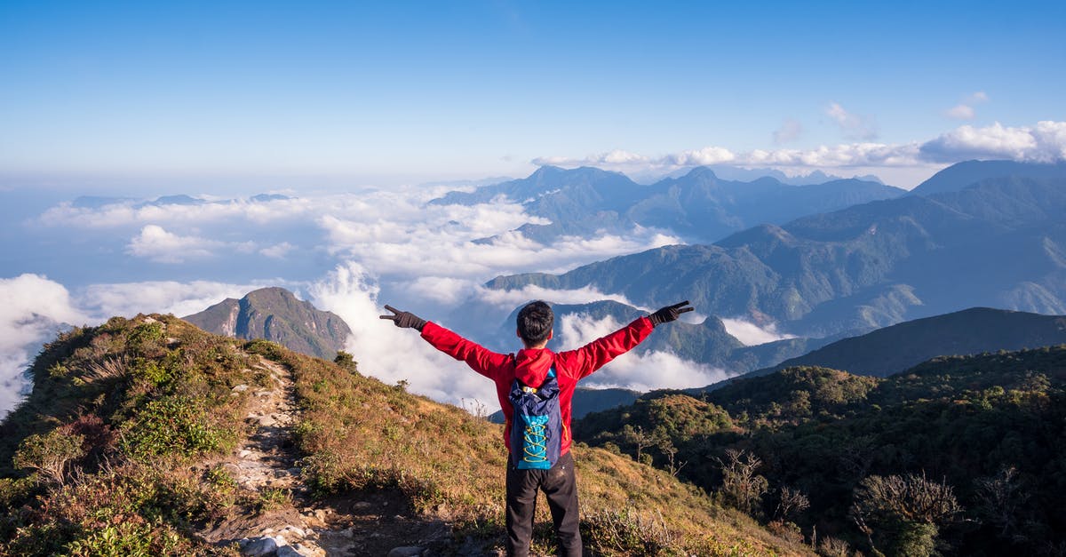 Traveling abroad with high end cryptography devices and software - Photo of Man Standing on Mountain While Doing Peace Sign