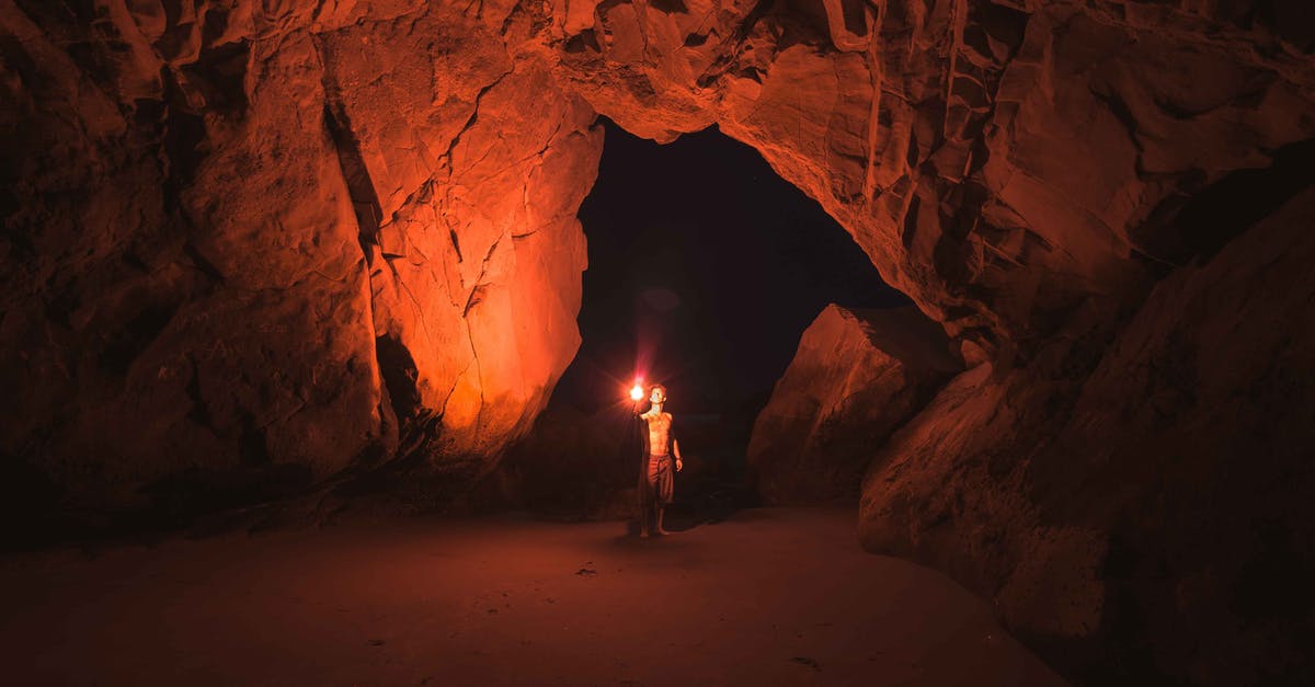 Traveling between California and Casper, WY - Person Standing and Holding Lamp Inside Cave