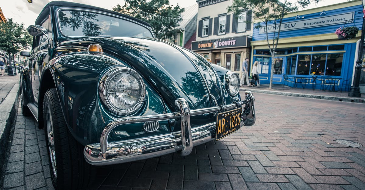 Traveling by own car from USA to Panama - Green Volkswagen Beetle Parked on Sidwalk