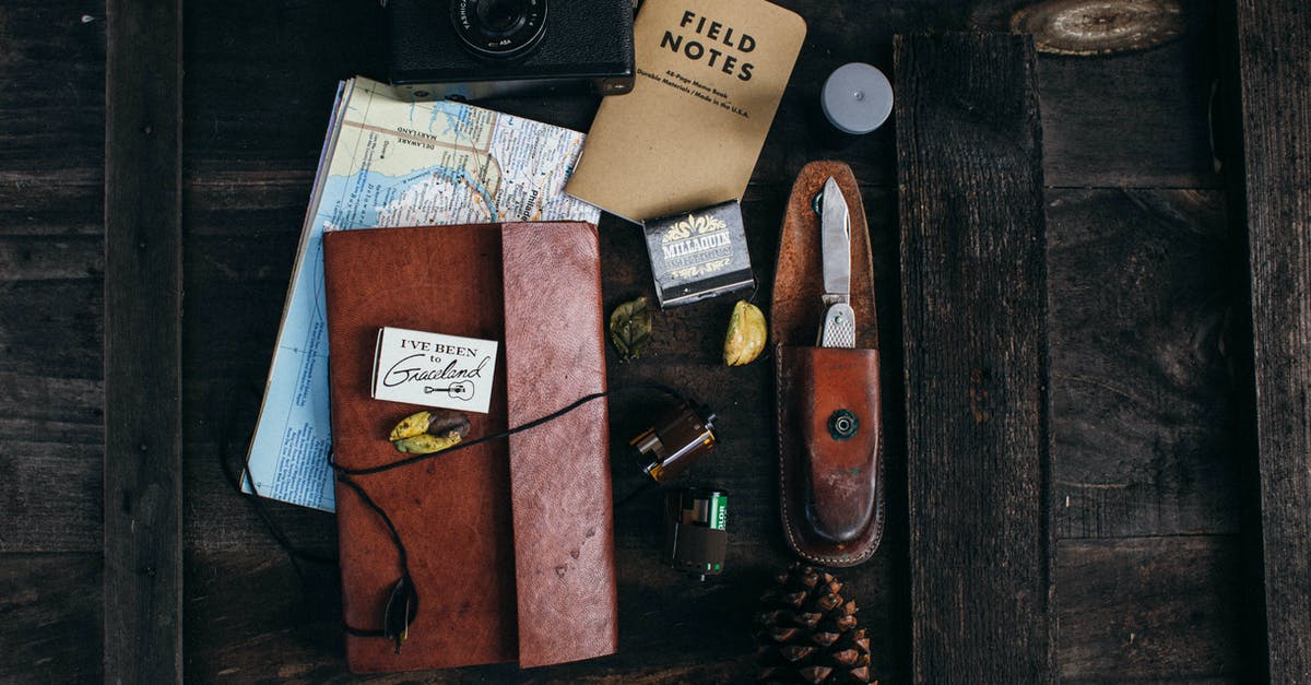 Traveling from Frankfurt to Karlsruhe - Retro camera near notepad and knife near map on desk