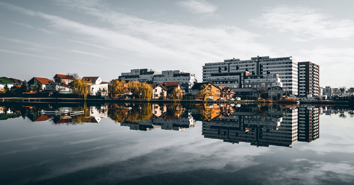 Traveling from Salt Lake City to Denver in late Autumn - Picturesque scenery of traditional houses and modern buildings located on shore of lake and reflecting in calm water on sunny autumn day