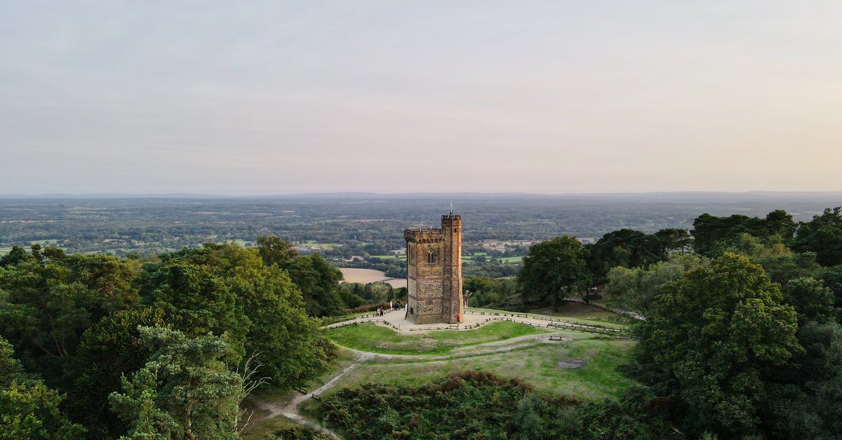 Traveling from United States to England twice within one year - Gothic medieval tower on green hill under sundown sky