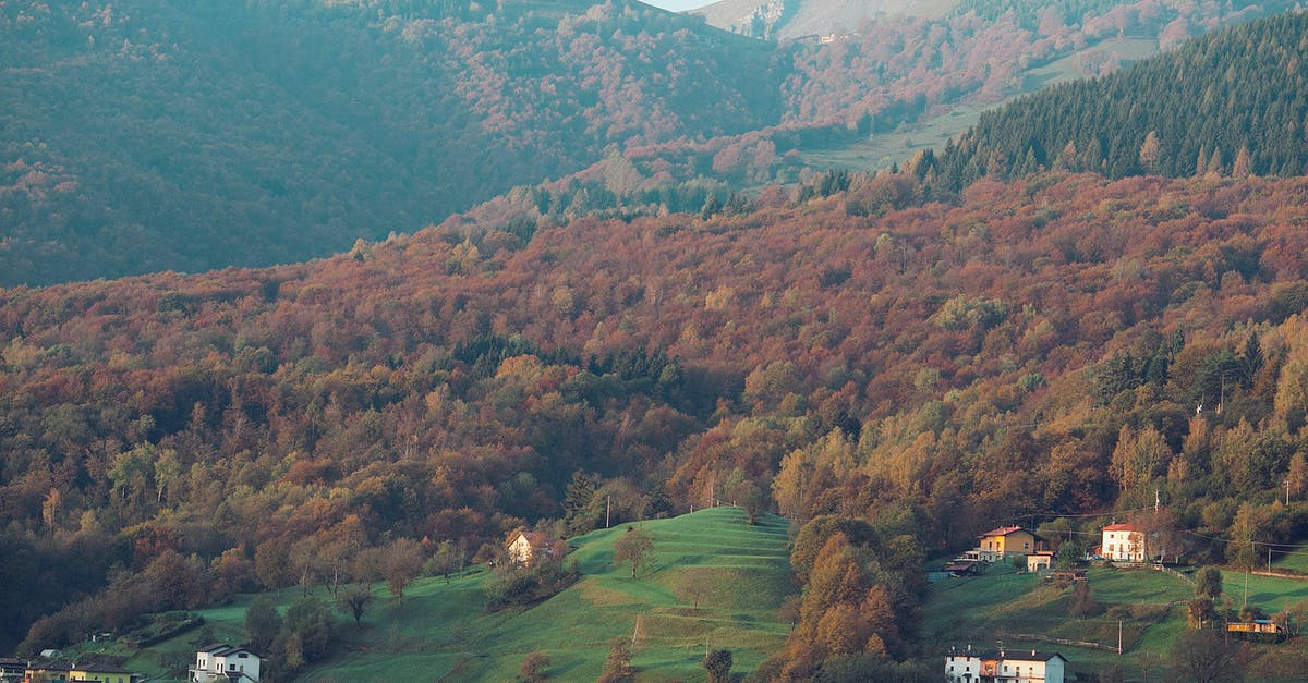 Traveling in Schengen area before going to the country that my type D visa is for - Drone view of peaceful valley covered with trees and small houses in mountainous area in daytime