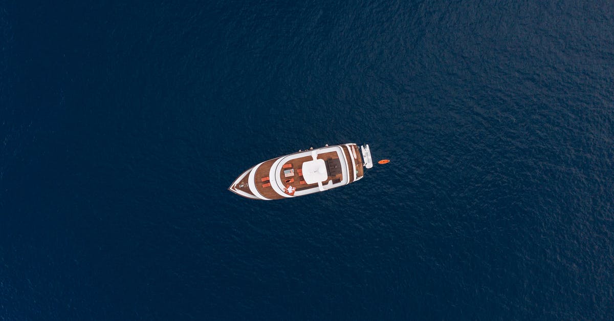 Traveling on a cruise ship from Singapore to Bejing - Drone top view contemporary yacht floating on dark blue rippling sea on cam windless day