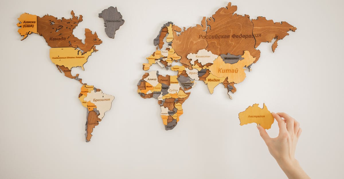 Traveling only with first and last name (instead of full name) - Unrecognizable person attaching world map on wall