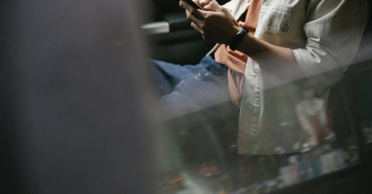 Traveling through Heathrow on separate tickets with no interline agreement - Crop man messaging on smartphone while sitting in car