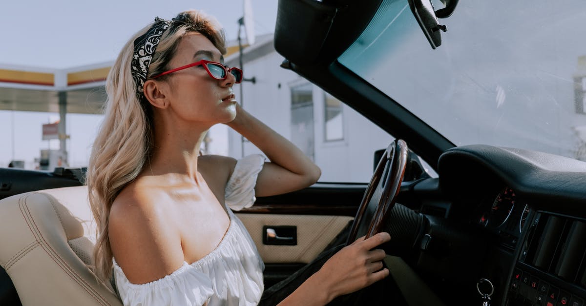 Traveling with a battery - A Woman Looking at Her Reflection on a Rear-view mirror