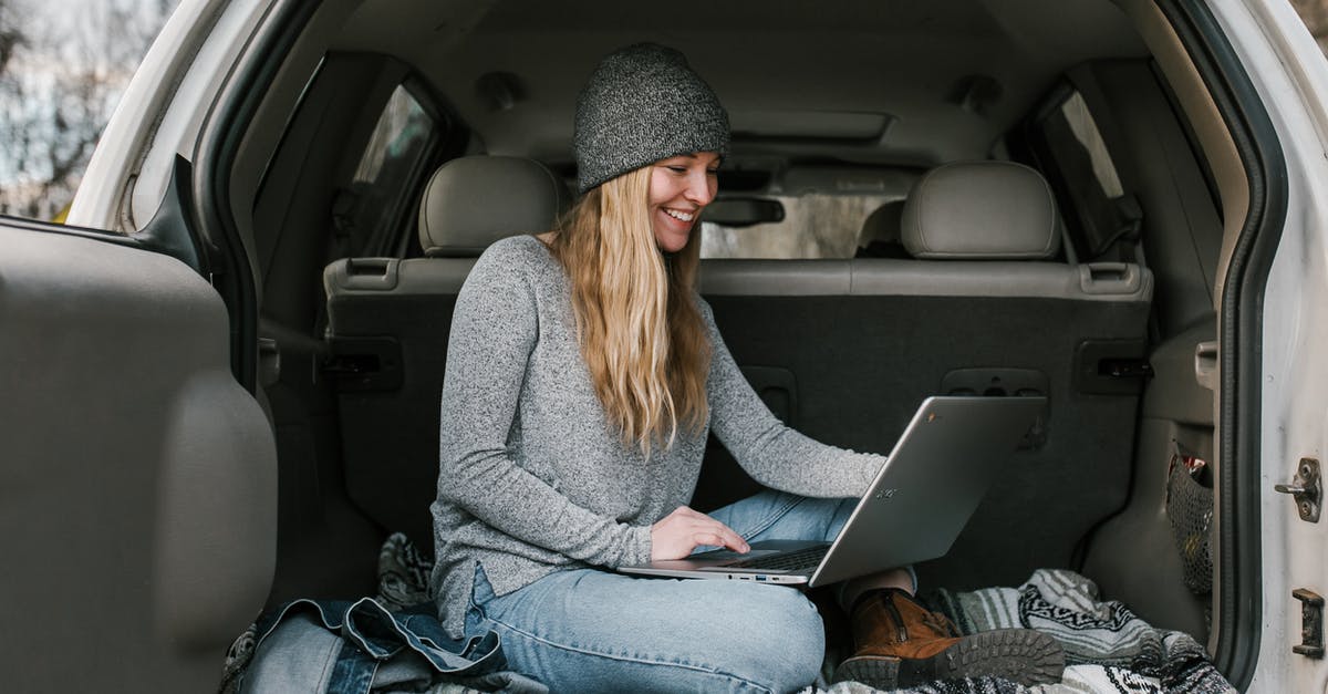 traveling with electronics - Woman in Gray Sweater and Blue Denim Jeans Sitting on Car Seat