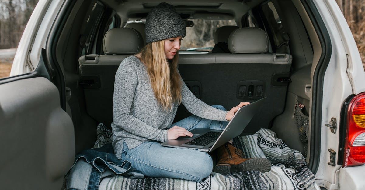 traveling with electronics - Woman in Gray Sweater and Blue Denim Jeans Sitting on Car Seat