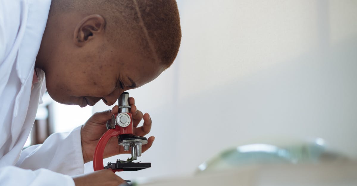 Traveling with medical equipment in checked baggage - Focused biologist studying plant leaf with microscope