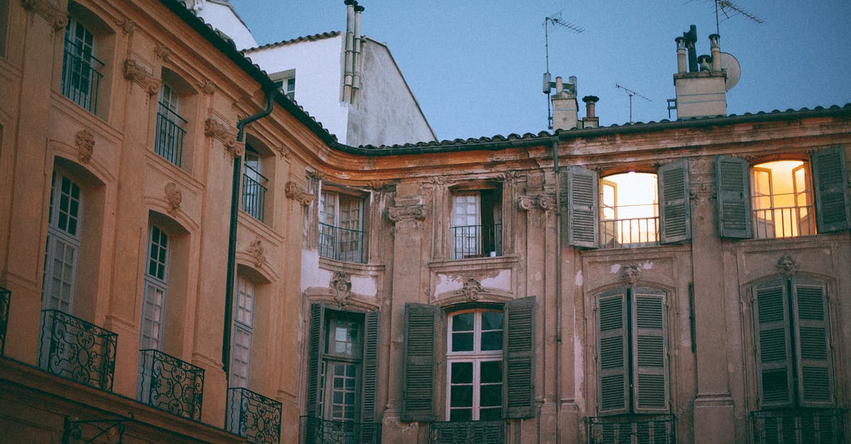 Travelling - Spain from France on 11 Feb - From below of facade of famous palace with pillars and shutters on windows and weathered wall located in Aix en Provence France