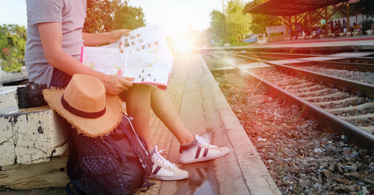 Travelling a day before my Schengen visa starts - Man Sitting Beside Black Backpack Near Railway