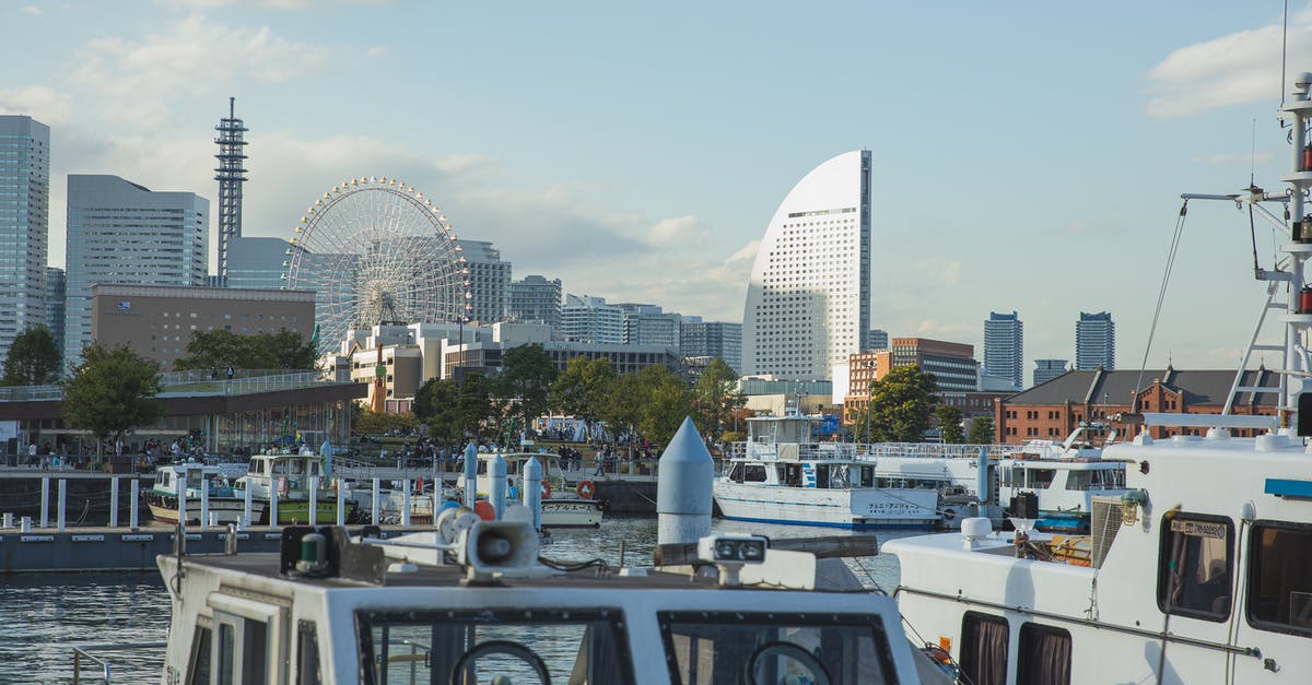 Travelling around Japan on a cruise ship - Vessels moored in harbor of modern urban city