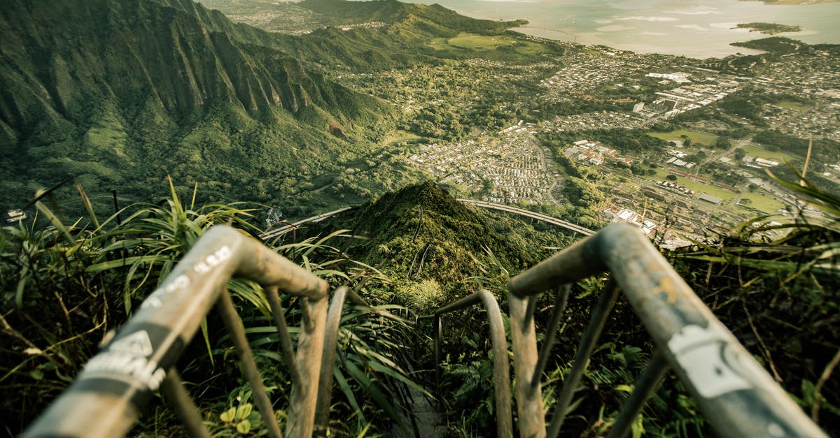 Travelling from India to Hawaii - From above of stairway leading down to tropical forest with breathtaking view of ocean surrounded with powerful mountains