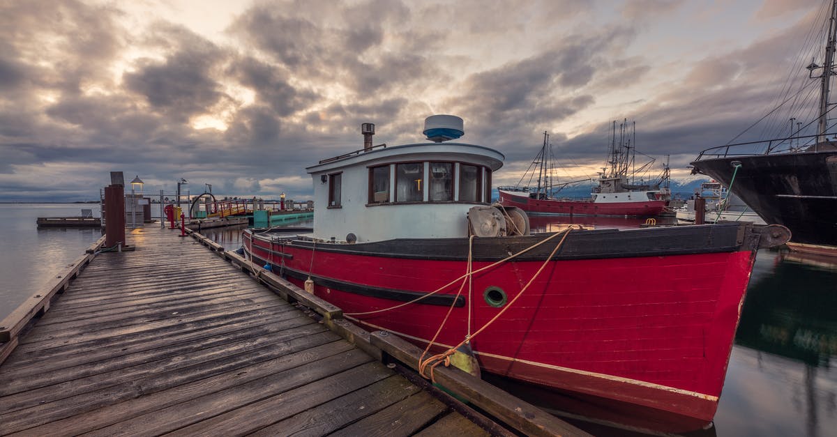 Travelling from USA to Canada by Ship - Red and White Boat on Dock Under Cloudy Sky