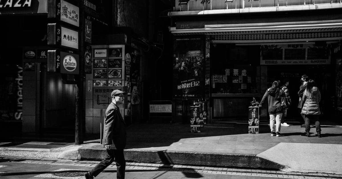 Travelling long-distance (Winnipeg – Auckland) with several stops as a blind person - Grayscale Photo of Man Walking on Sidewalk