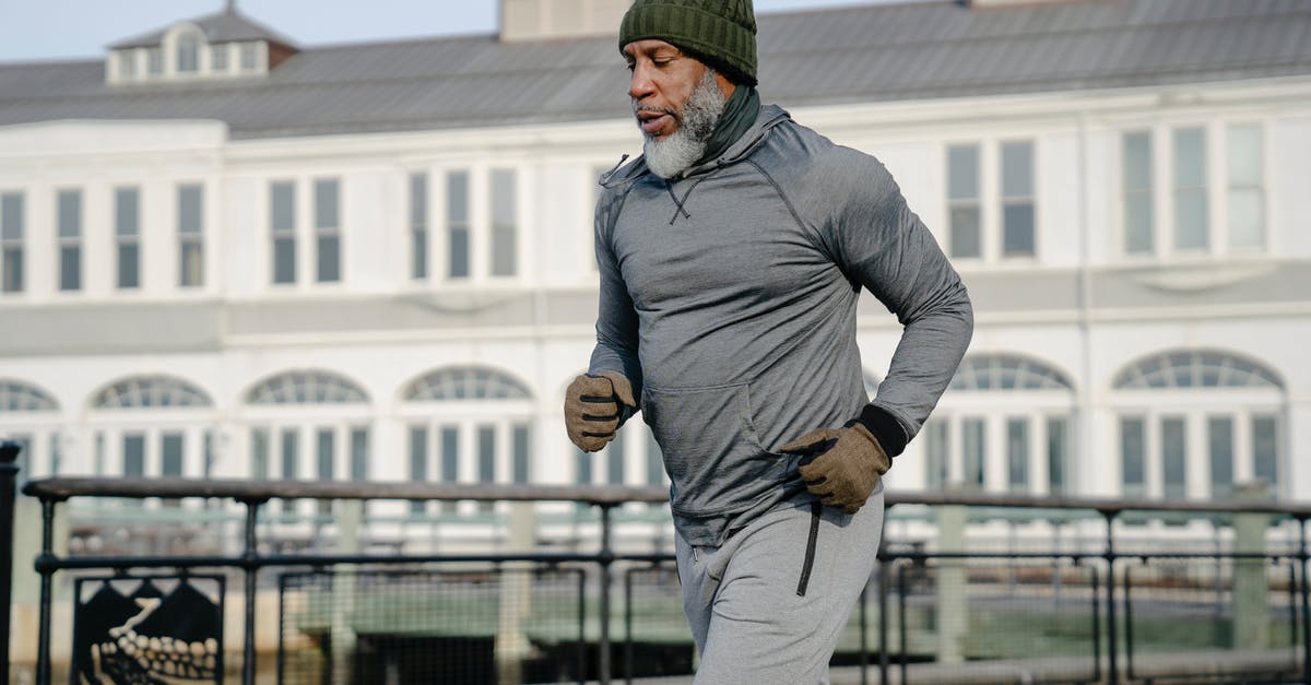 Travelling outside the USA while on Optional Practical Training (OPT) [closed] - Concentrated African American bearded aged male athlete with closed eyes in activewear running on city street in sunny day