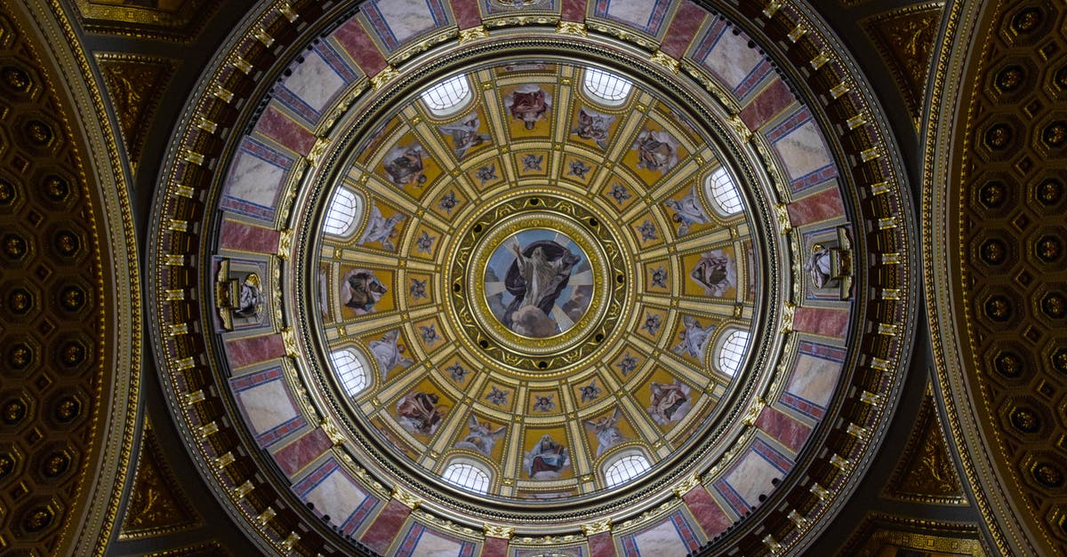 Travelling restrictions from Budapest, Hungary to Lisbon, Portugal - From below majestic interior ornamental dome of St. Stephen Basilica with religious paintings and mosaic elements located in Budapest