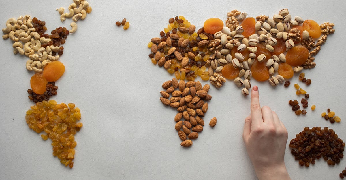 Travelling to Asia and Oceania with a peanut and pistachio allergy - Faceless person making world map with nuts and dried fruits