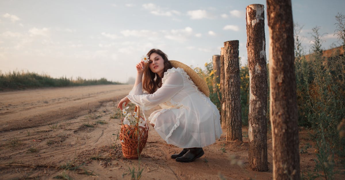 Travelling to Kuwait by Road - Woman in White Dress Crouching by the Road 