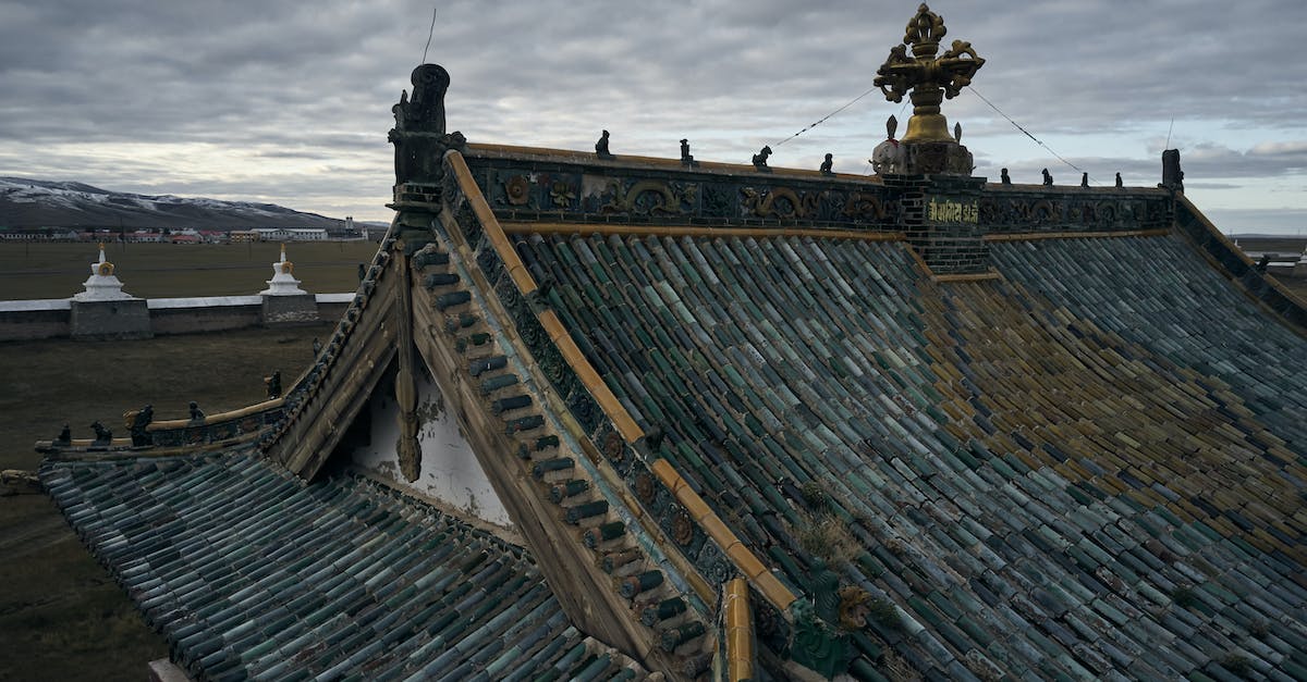 Travelling to Kyzyl, Tuva from Mörön, Mongolia - From above of ancient Erdene Zuu Buddhist monastery with tiled roof and decorative roof elements under overcast sky in evening