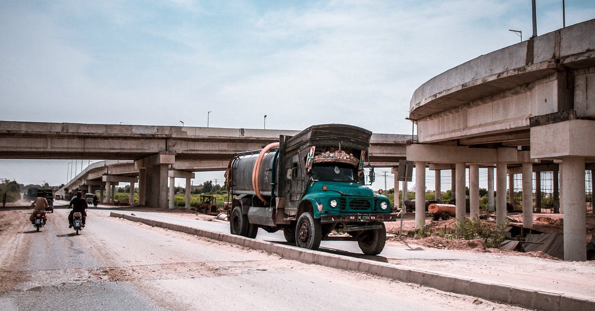 Travelling to Pakistan with expired Pakistani passport? - Blue and Black Truck on Road Near Building and Two Motorcycles