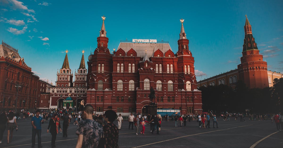 Travelling to Russia with Refugee Travel document issued in USA - Exterior of square with tourists walking near State Historical Museum building in Red Square Moscow Russia under blue cloudy sky