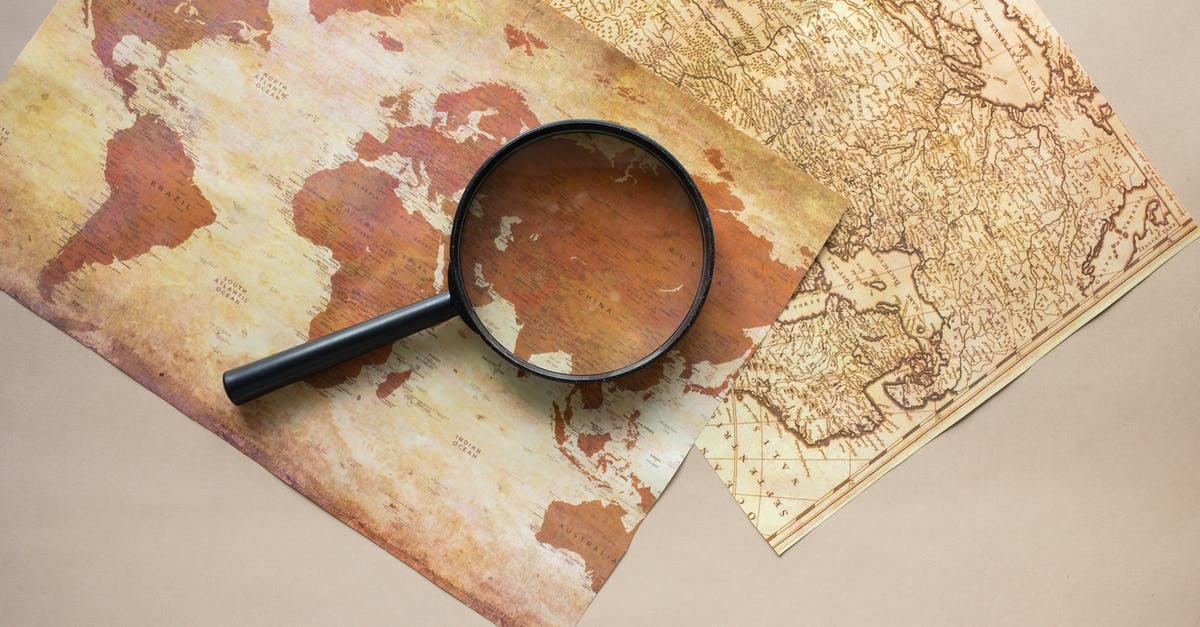 Travelling with research equipment - Magnifying glass placed on maps