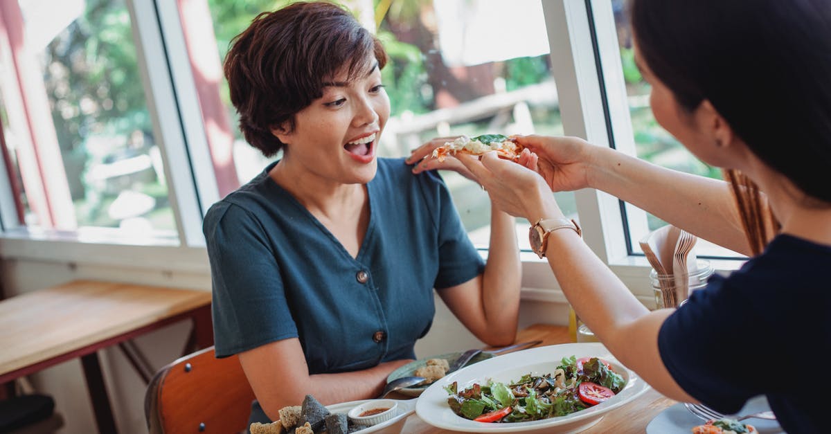 Trying to find a specific restaurant in Jerusalem - Crop woman feeding pizza to friend