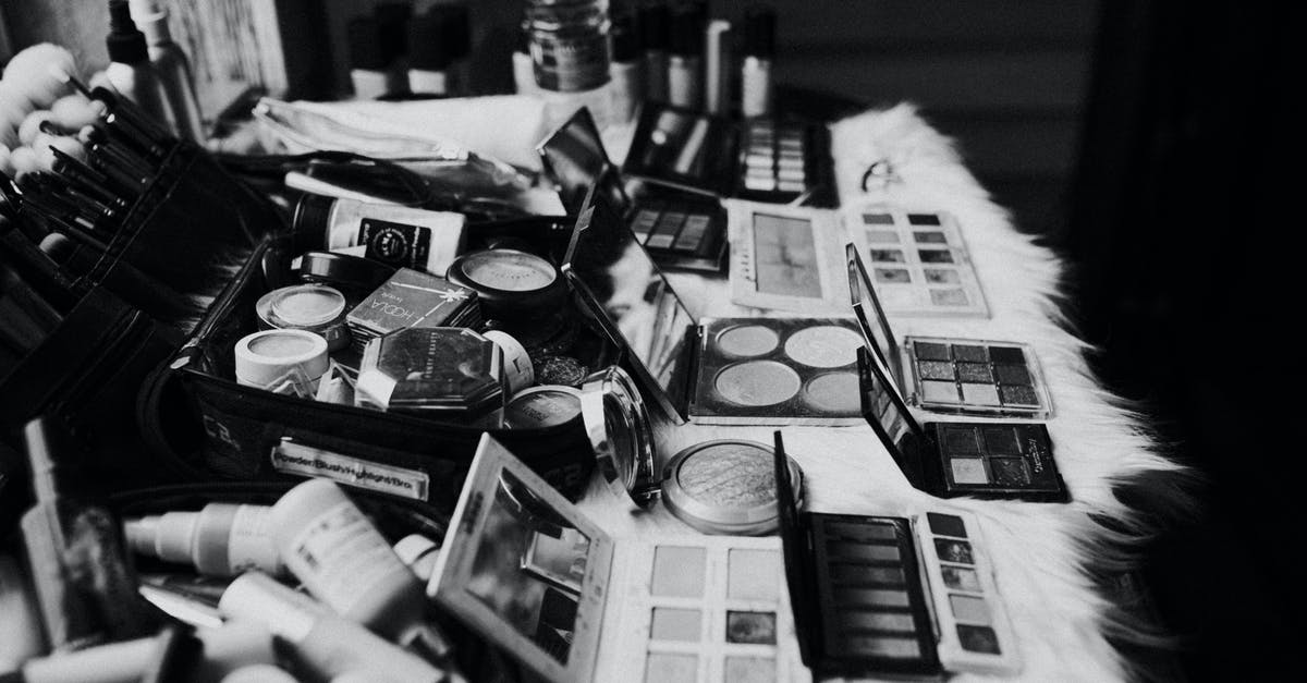 Tube from Heathrow to King's Cross - Black and white high angle of assorted makeup products and tools placed on dressing table near mirror