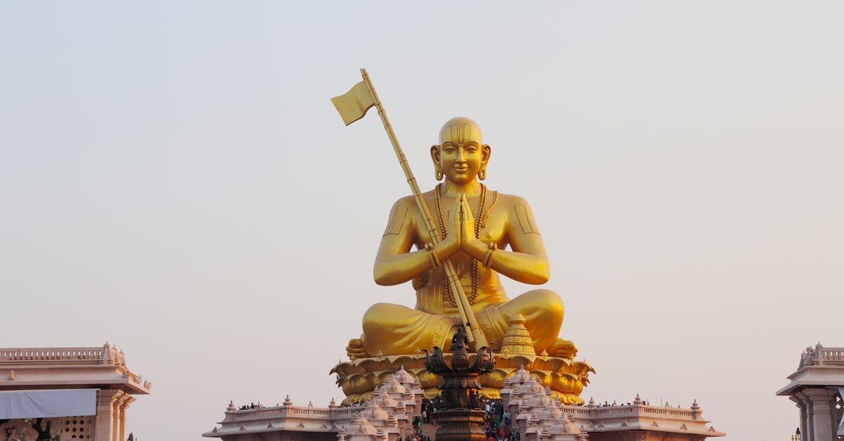 Two passports for the same person in India - Gold Statue of Man Holding Flag