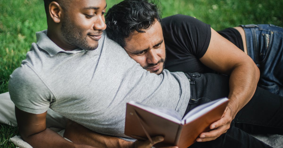 Two passports, two different names, booked a flight - Two Adult Men Lying Together and Reading Book