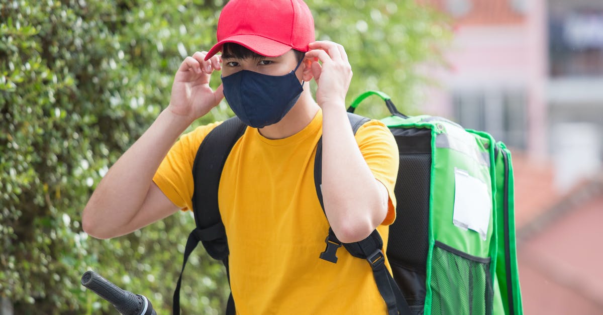 UK courier for delivering covid-19 test (fit-to-fly requirements) - A Delivery Person Putting on a Face Mask