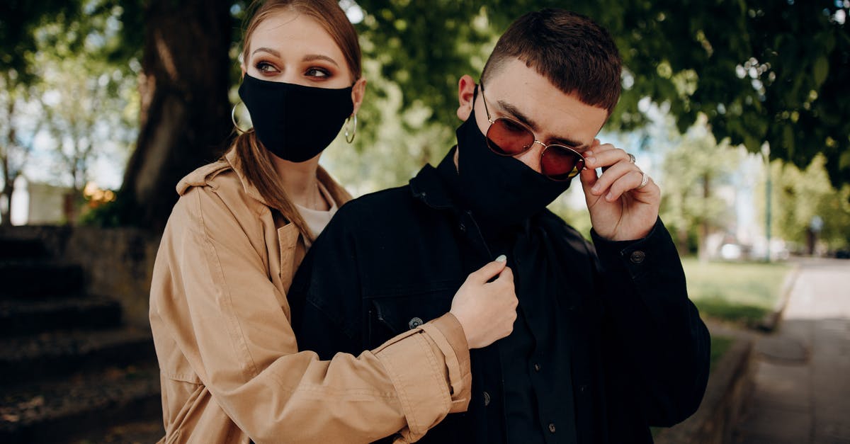 UK COVID Test-to-release programs starting date - Couple in masks embracing and looking away