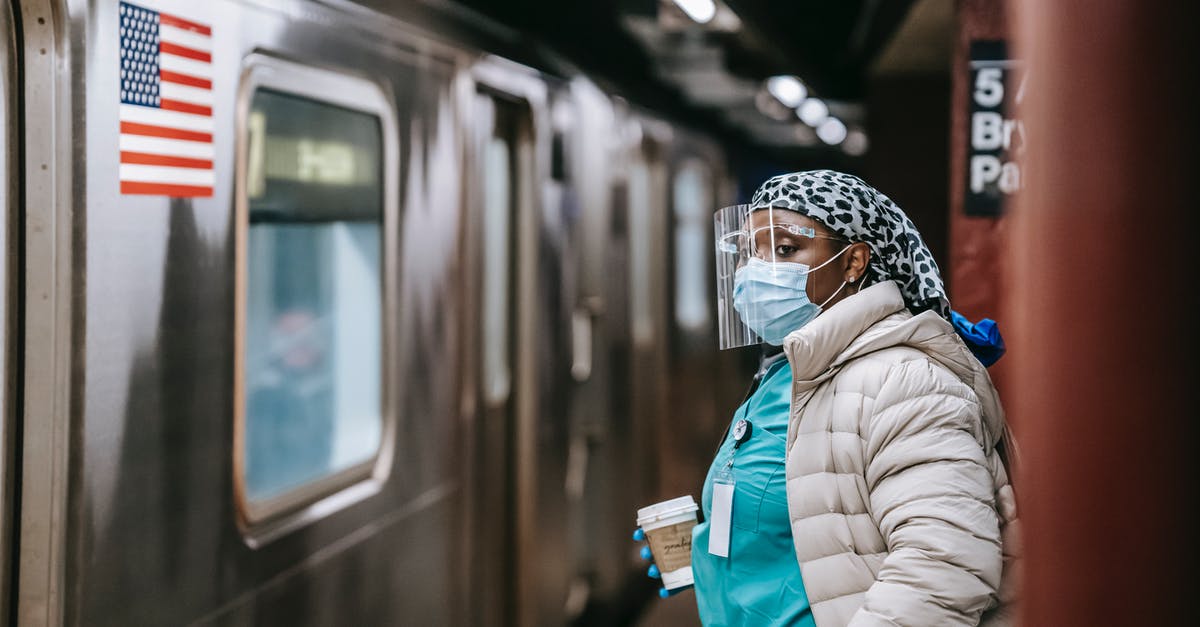 UK last train cancellation and unhelpful staff - what to do? - Nurse in protective mask and coat waiting for train on subway station