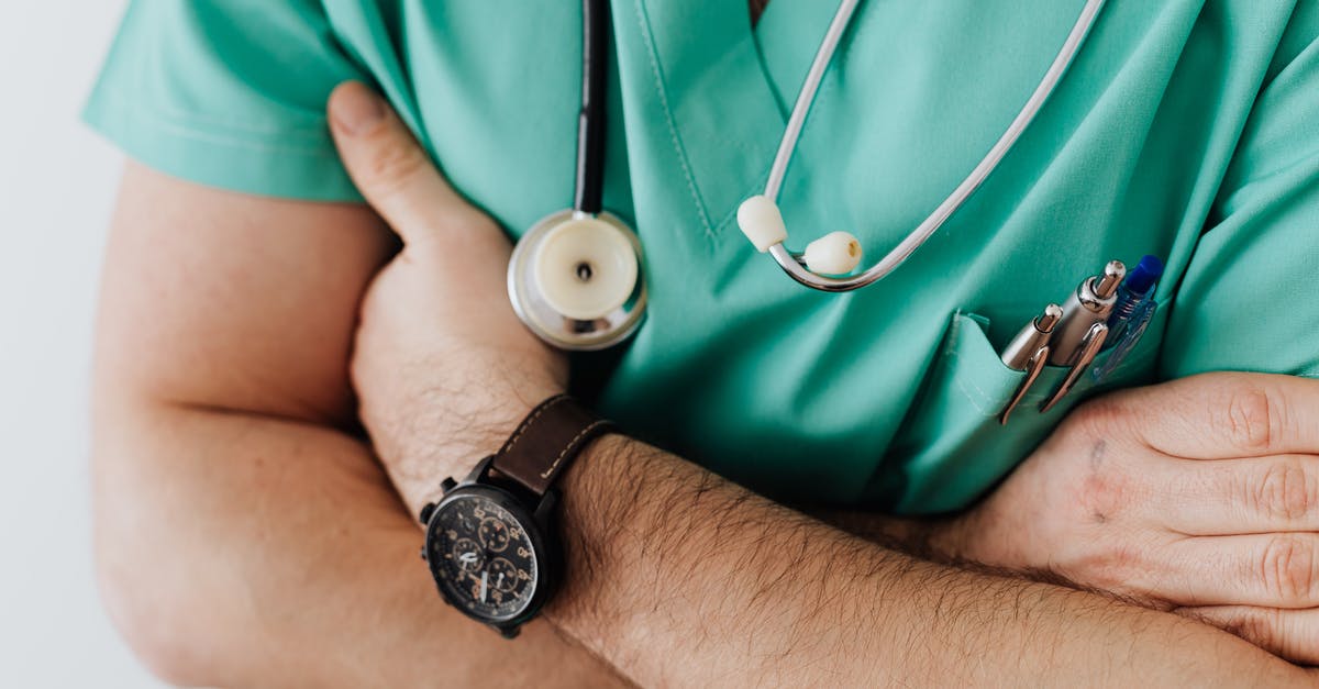 UK Secondary Medical Care for Visitors and Tourists - Crop doctor with stethoscope in hospital