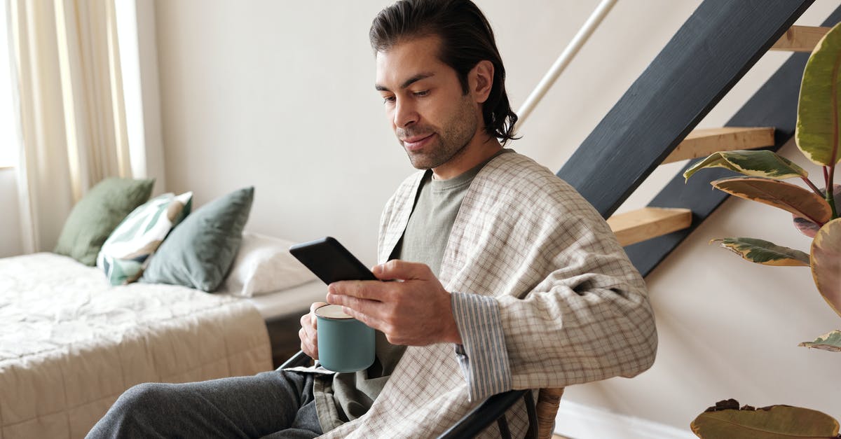 UK Visa Application for Self Employed - Man Looking At His Cellphone While Having Coffee