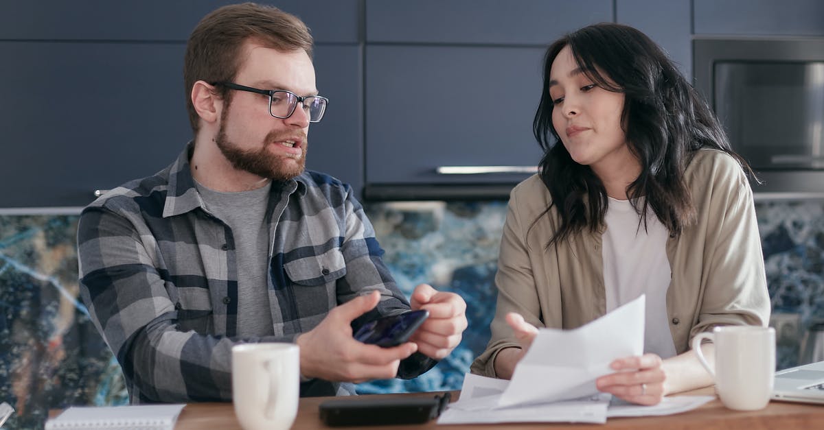 UK visa for husband - Man and Woman Sitting at Table