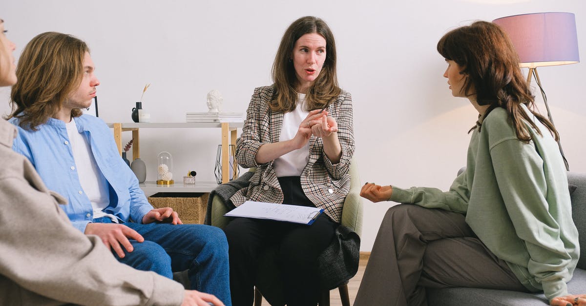 UK Visa group appointment - Female therapist during group session talking to female patients gathering in light cozy office